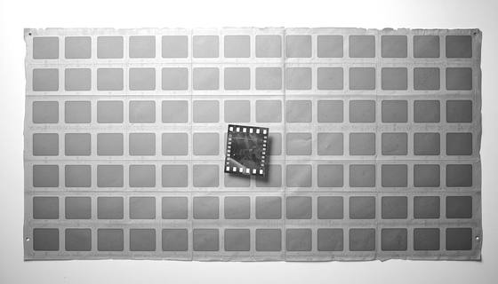 A photographic contact sheet of many identical frames, with one frame turned out of alignment.